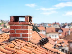 Nowoczesny dom jednorodzinny z prostą opaską wokół budynku z płyt betonowych i żwiru, otoczony niską trawą i krzewami.